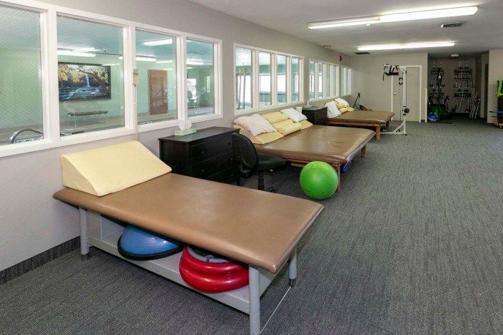 A physical therapy room equipped with treatment beds and exercise equipment.
