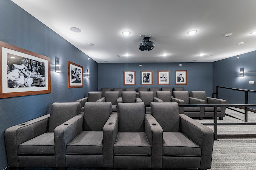 A cozy home theater setup featuring comfortable gray chairs and framed photographs on the wall.