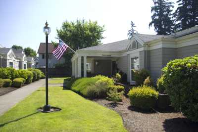 A suburban house with a well-maintained lawn and an American flag displayed outside.