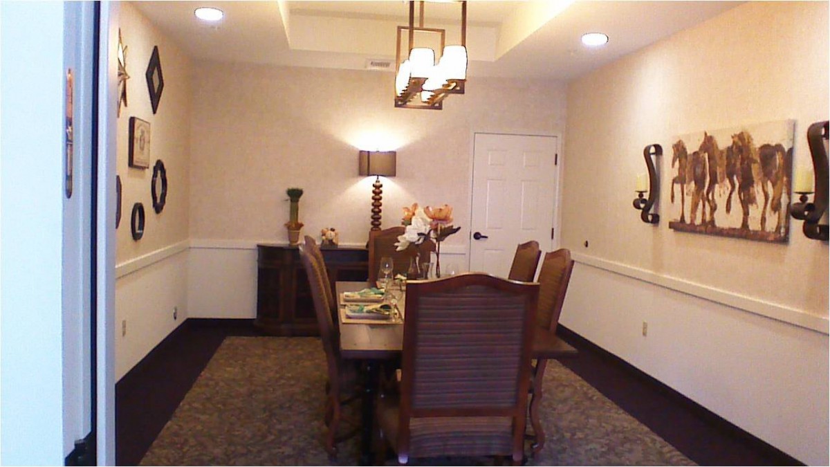 A well-appointed dining room featuring a wooden table and matching chairs, accented by elegant lighting and decor.