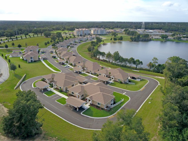 Aerial view of a suburban neighborhood with houses surrounding a lake.