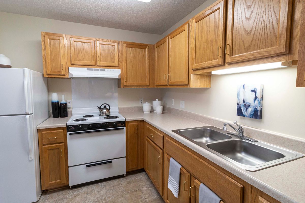 A cozy kitchen with wooden cabinets and a white stove.