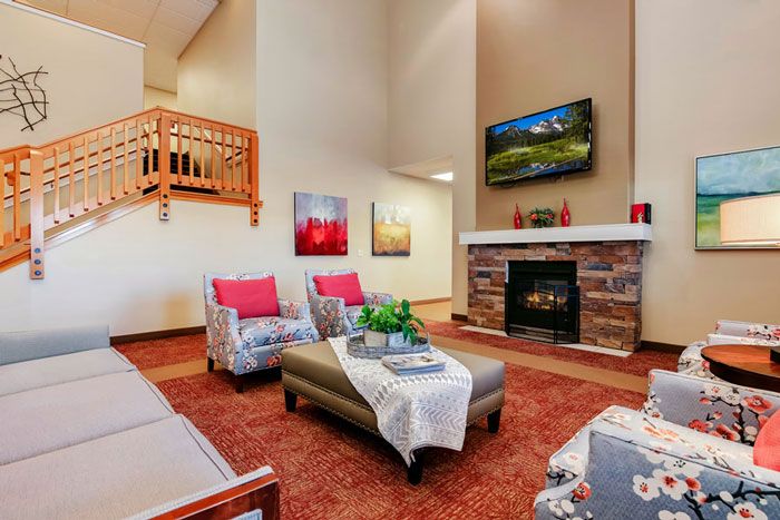 A modern living room with a cozy fireplace, stylish furniture, and decorative artwork.
