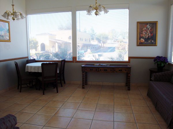 An empty restaurant interior with tables and chairs near large windows.
