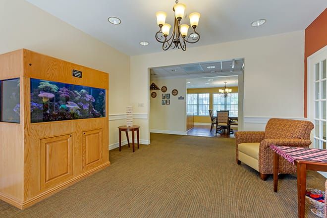 A cozy living room featuring an aquarium, chandelier, and comfortable seating.