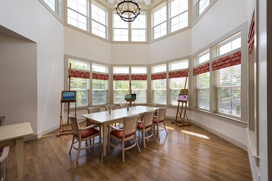 A bright dining room with large windows and elegant furnishings.
