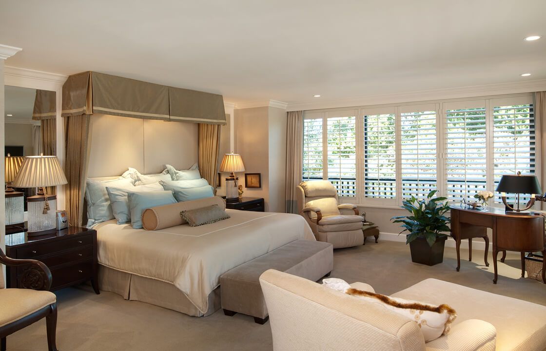 A luxurious bedroom with elegant furnishings and large windows.