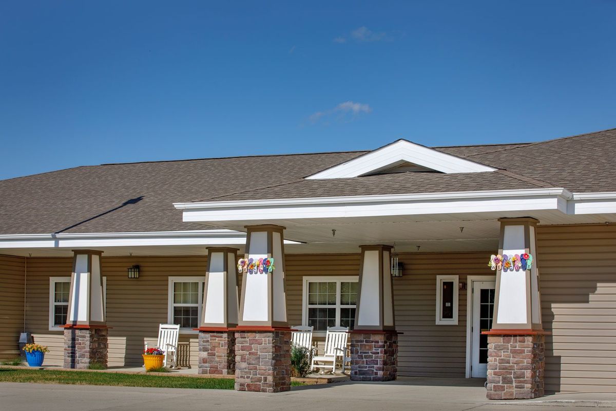 A residential building with a welcoming entrance and porch on a clear day.