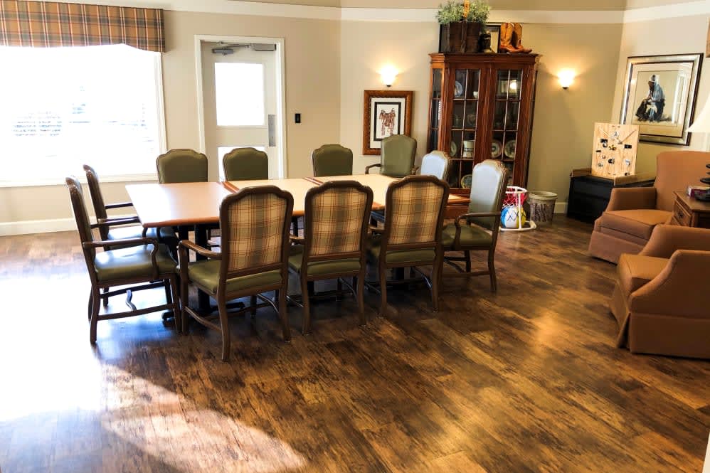 A well-furnished dining room with a wooden table, chairs, and a cabinet.