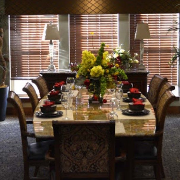 A beautifully set dining table with floral centerpieces and elegant tableware.