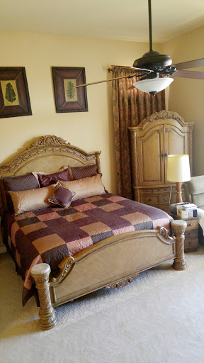 A beautifully decorated bedroom featuring a classic-style bed with ornate detailing and coordinated accessories.