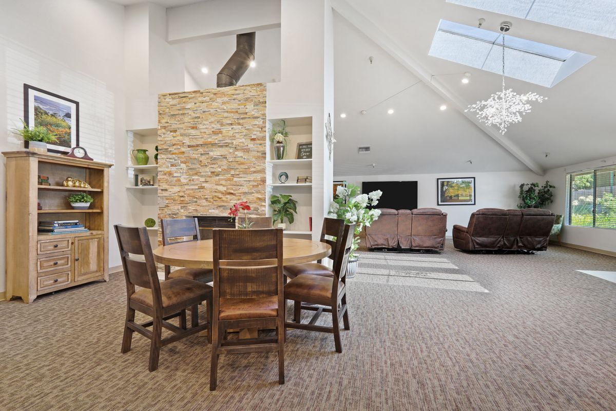 A spacious and modern open-concept living and dining area with stylish furniture and a cozy fireplace.