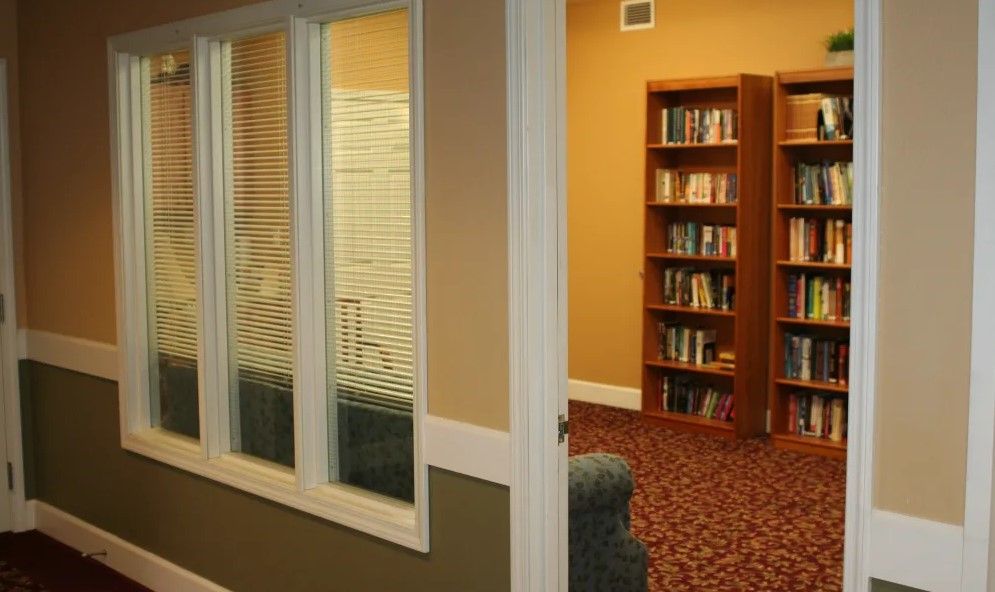 A cozy library room with bookshelves and a window view.