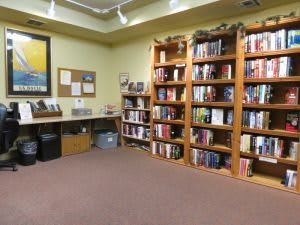 A cozy library corner with wooden bookshelves filled with a variety of books.