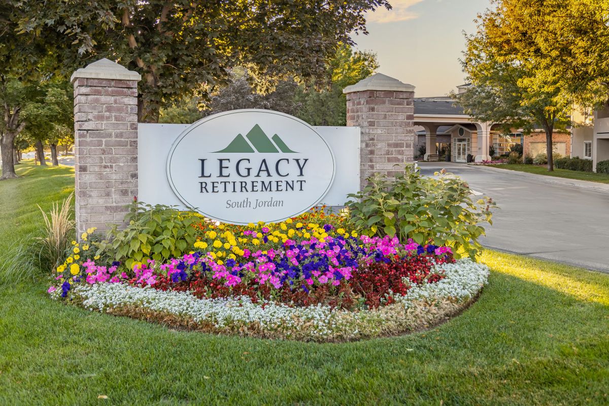 Entrance sign with colorful landscaping at a retirement community.
