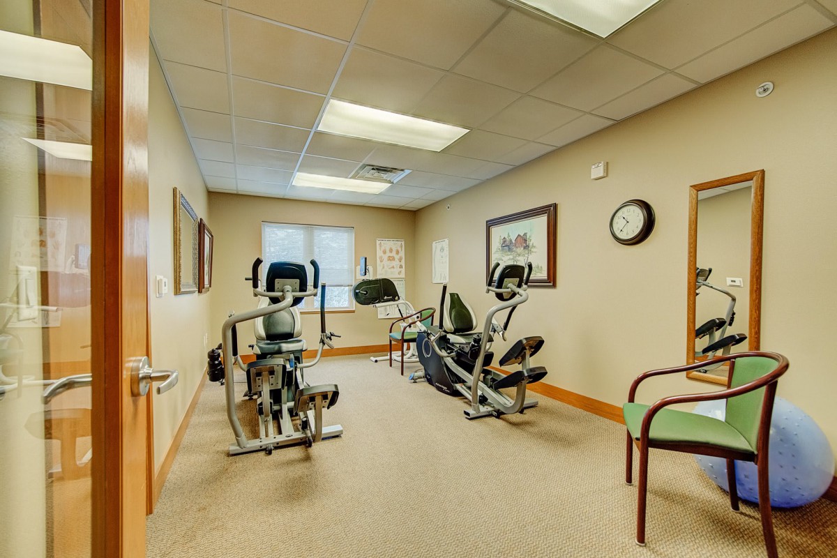 A small gym with exercise equipment and seating.