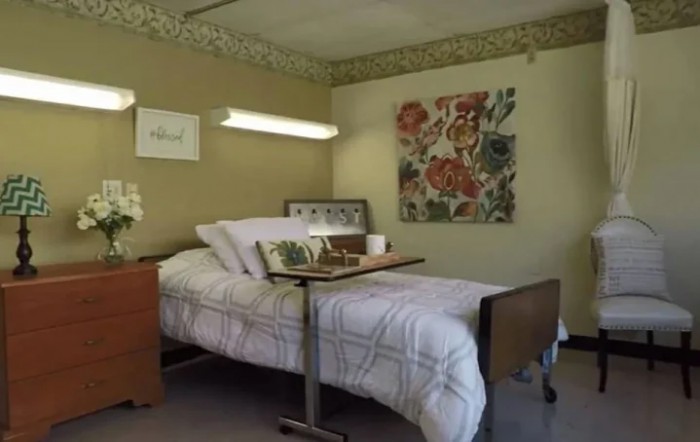 A well-arranged hospital room with a bed and a tray table, decorated with floral artwork on the wall.