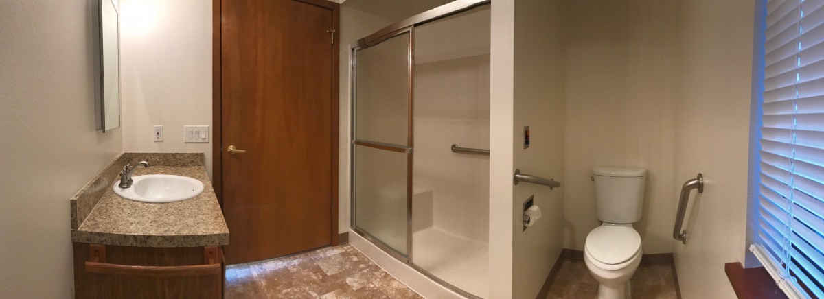 A modern bathroom with a glass-enclosed shower and tiled flooring.