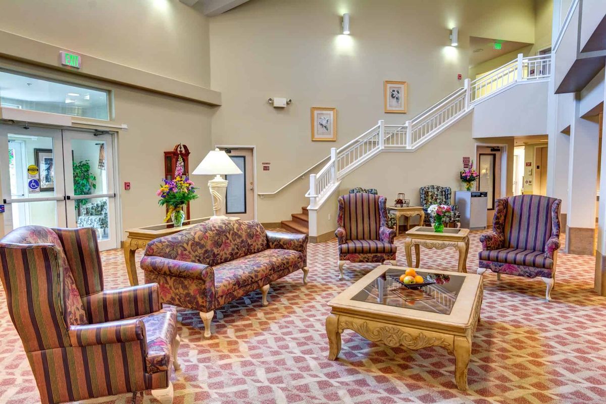 A spacious lobby area featuring classic furniture, decorative elements, and a staircase leading to an upper level.