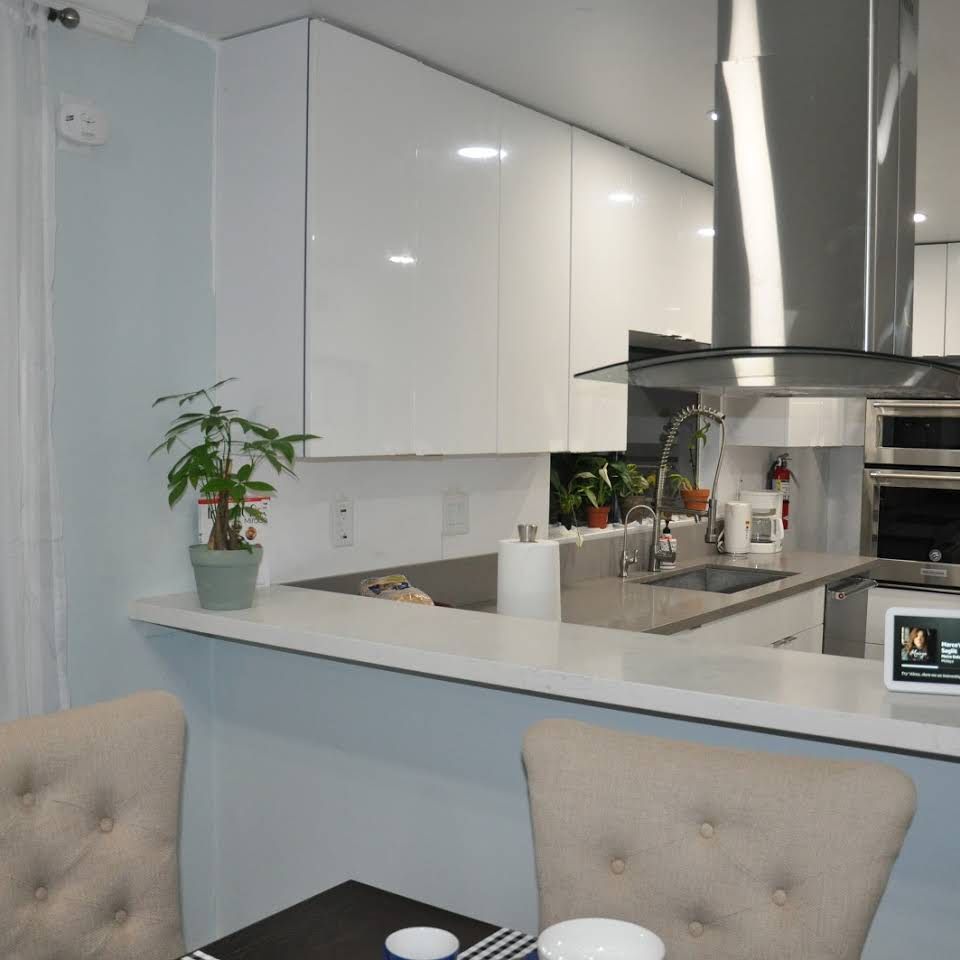 A modern kitchen with white cabinets and stainless steel appliances.