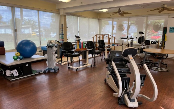A physical therapy room equipped with various exercise machines and rehabilitation tools.
