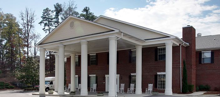 A brick building with a large porch and white columns.
