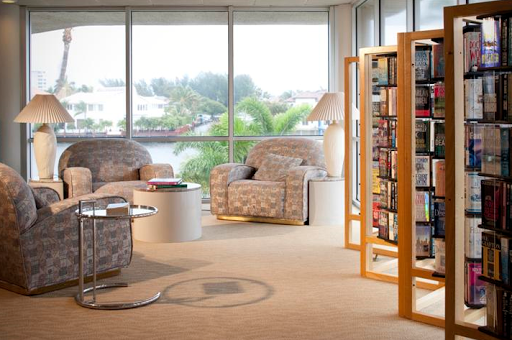 A cozy modern living room featuring comfortable seating and a stylish bookshelf, bathed in natural light.