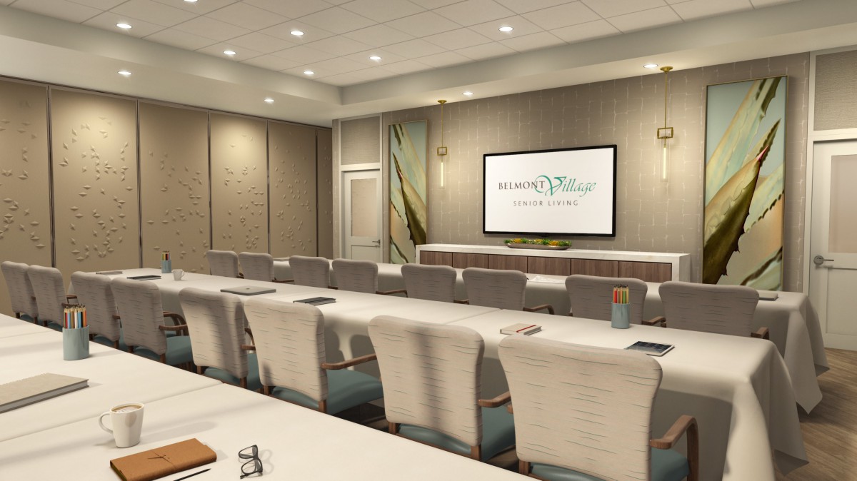 A conference room set up with tables and chairs facing a projector screen.