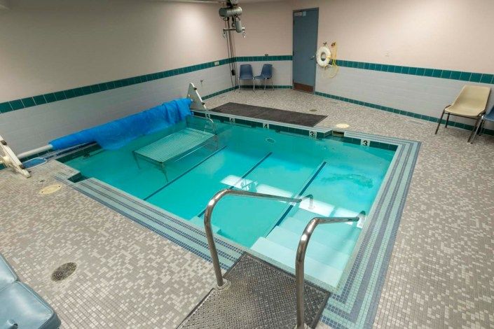 An indoor therapy pool equipped for rehabilitation and exercise.