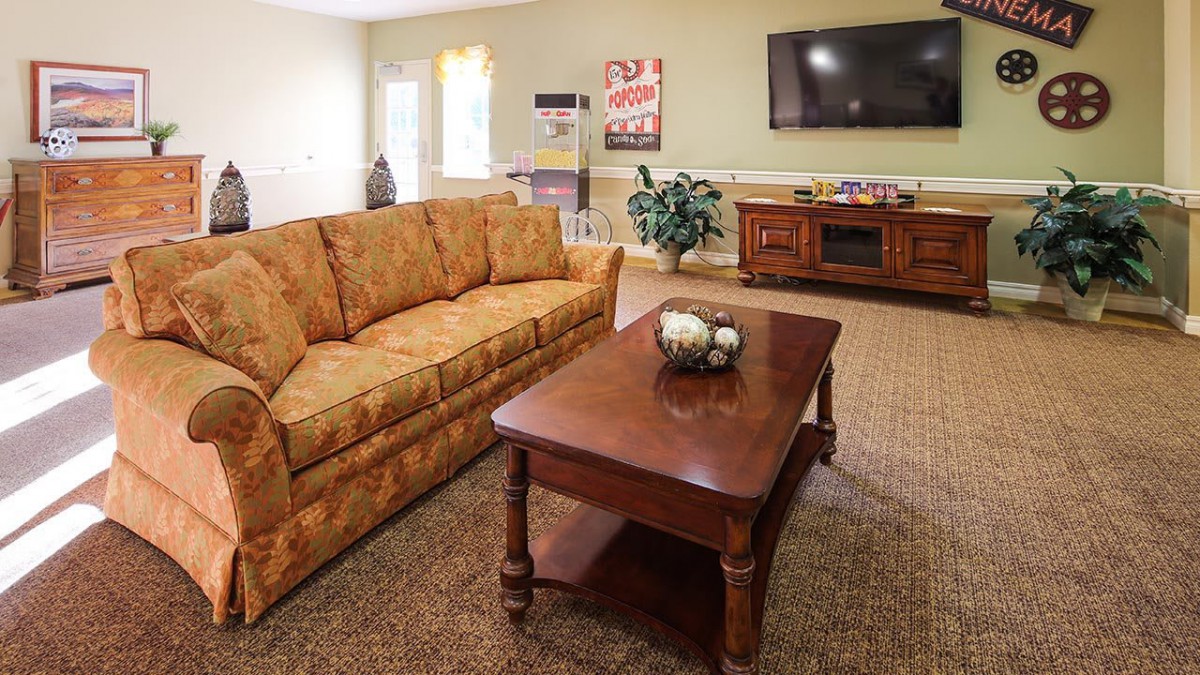 A cozy living room with a sofa, coffee table, and television.