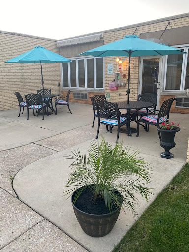 A cozy outdoor patio setup featuring tables, chairs, and vibrant umbrellas for shade.
