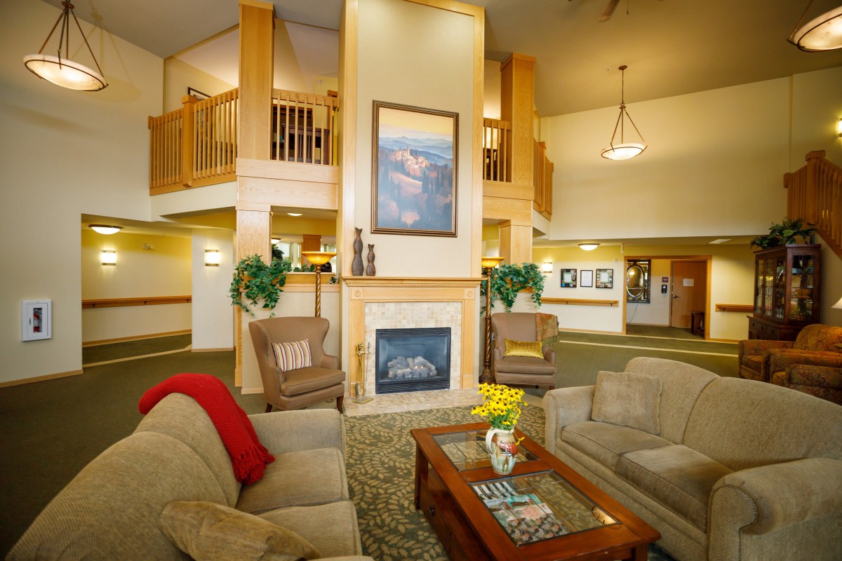 A cozy hotel lobby featuring a fireplace and comfortable seating.
