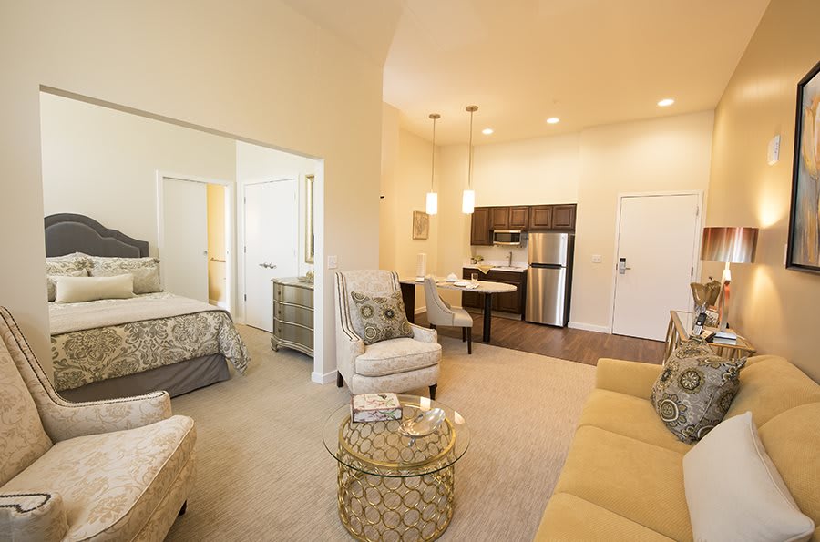 A cozy and modern open floor plan apartment with a living room, kitchen, and bedroom.