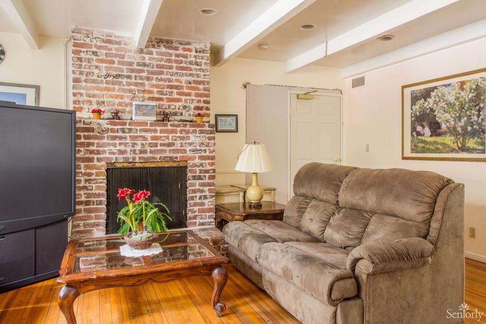 Cozy living room with a brick fireplace and comfortable seating.
