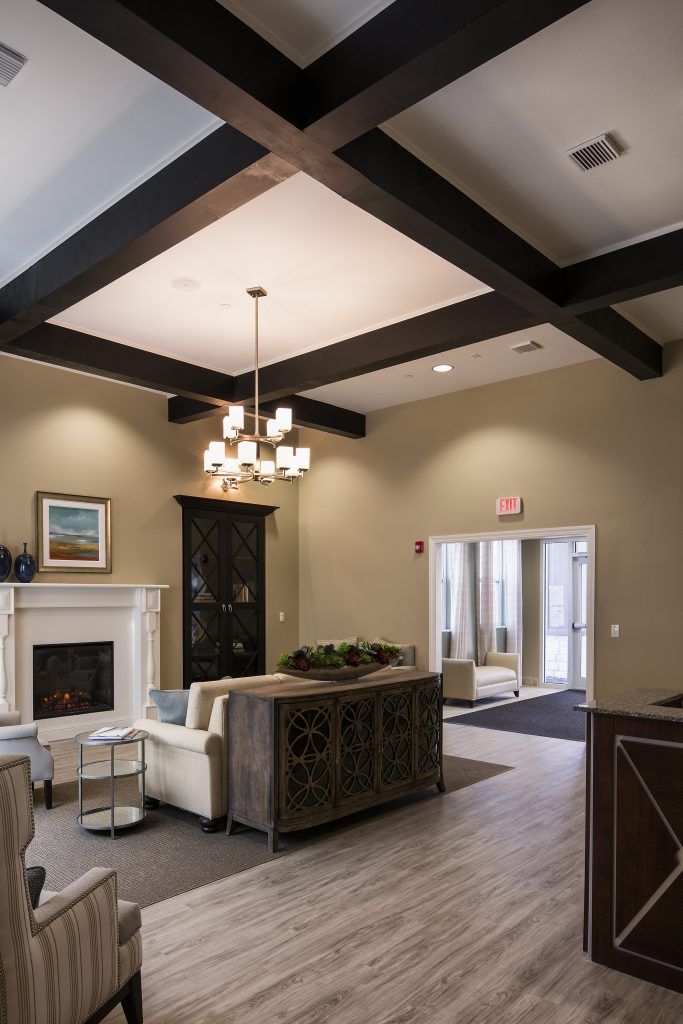 A modern living room featuring a fireplace, elegant chandelier, and comfortable seating area.