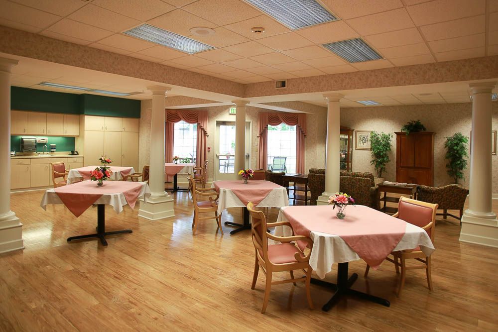 A cozy dining area with neatly arranged tables and chairs in a warmly lit environment.