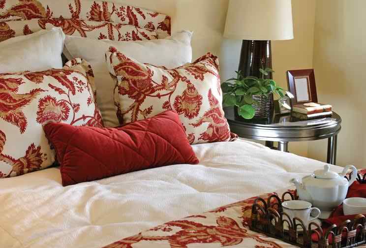 A cozy bedroom setup featuring red and white floral patterned pillows.