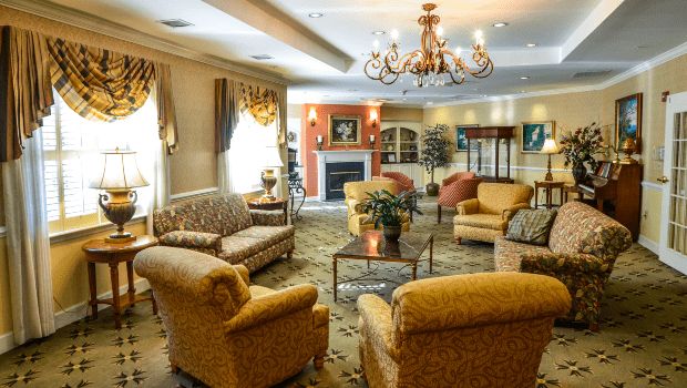 Elegant living room with a chandelier, comfortable seating, and a fireplace.
