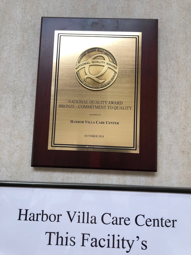 A wall-mounted plaque recognizing Harbor Villa Care Center for outstanding achievement.