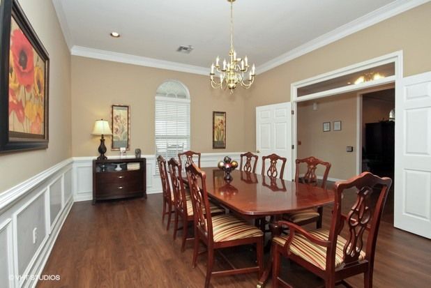 Elegant dining room with a large wooden table and chandelier.