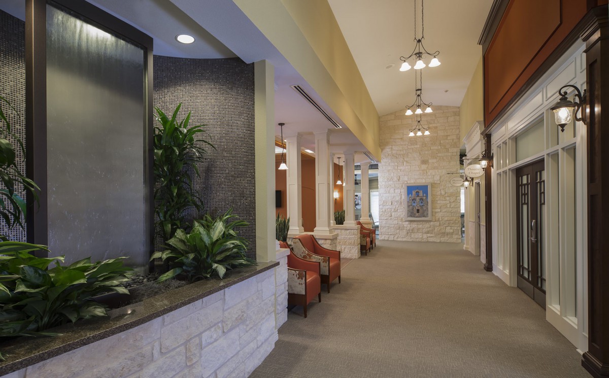A spacious lobby with seating, plants, and decorative lighting.