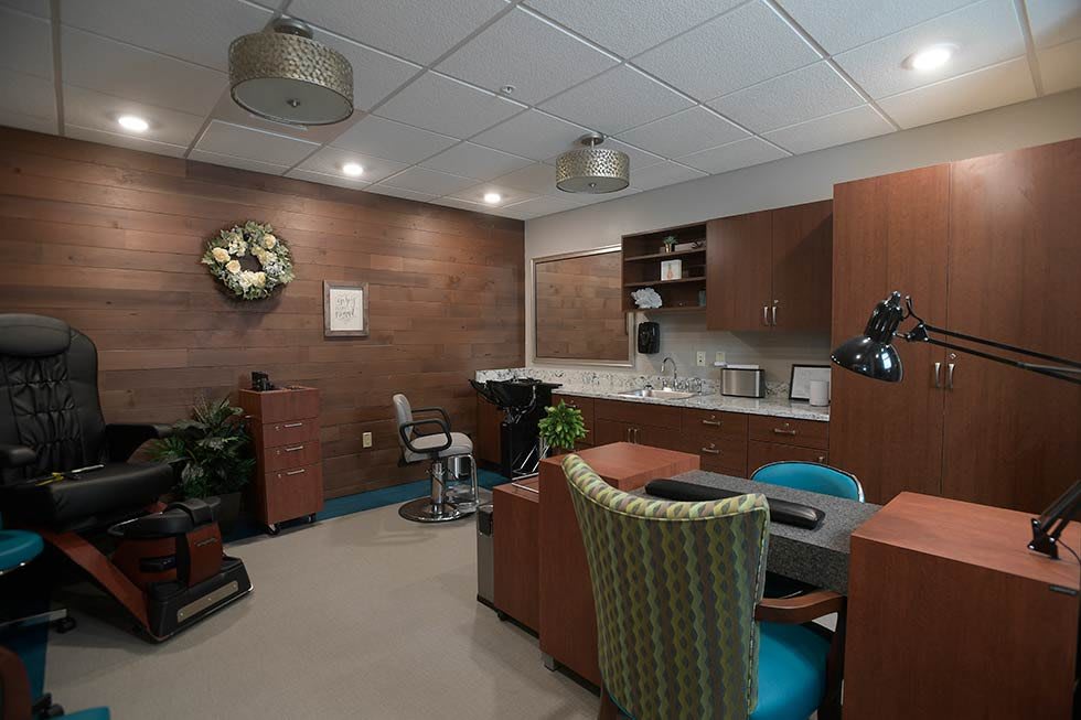 A modern office workspace with a desk, chairs, and cabinetry.