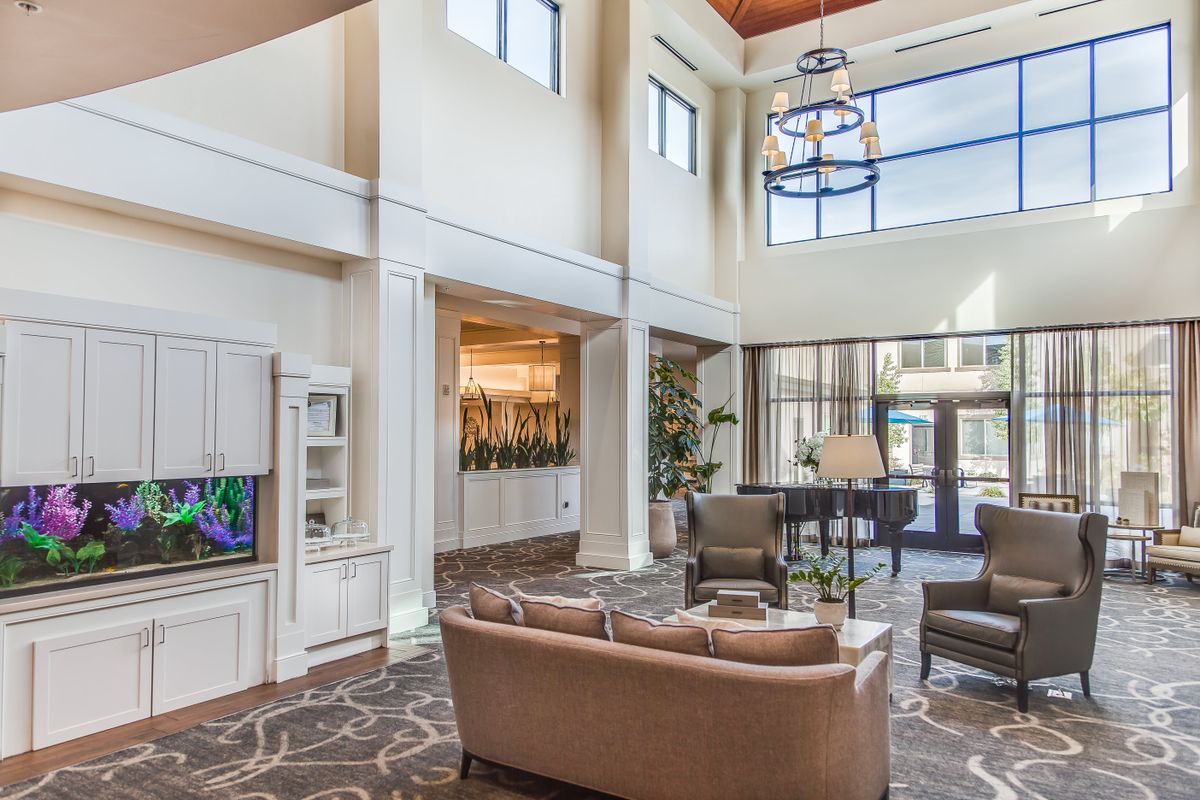 A spacious lobby area with comfortable seating and a grand piano.