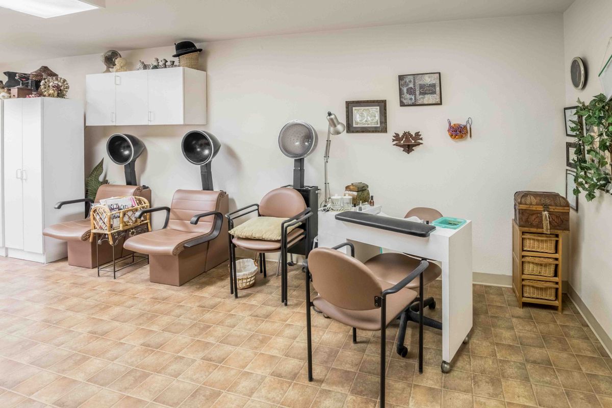 A cozy beauty salon interior with hair dryers and comfortable seating.