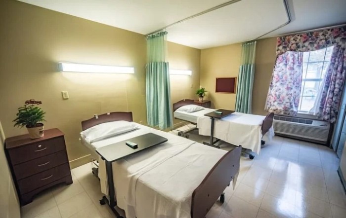 A hospital room with two beds separated by curtains.
