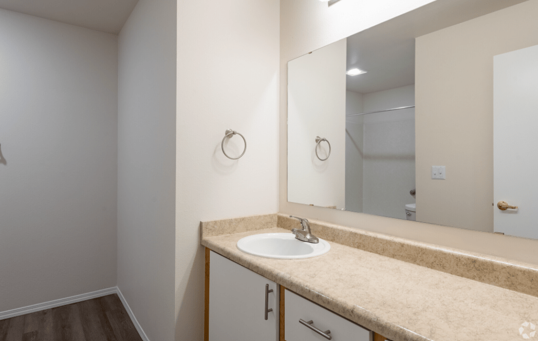 A minimalist bathroom with a single sink and mirror.