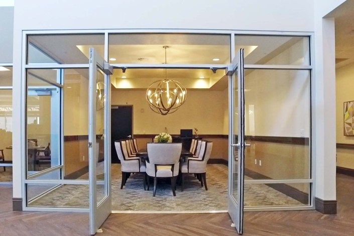 A modern conference room with a chandelier and glass doors.