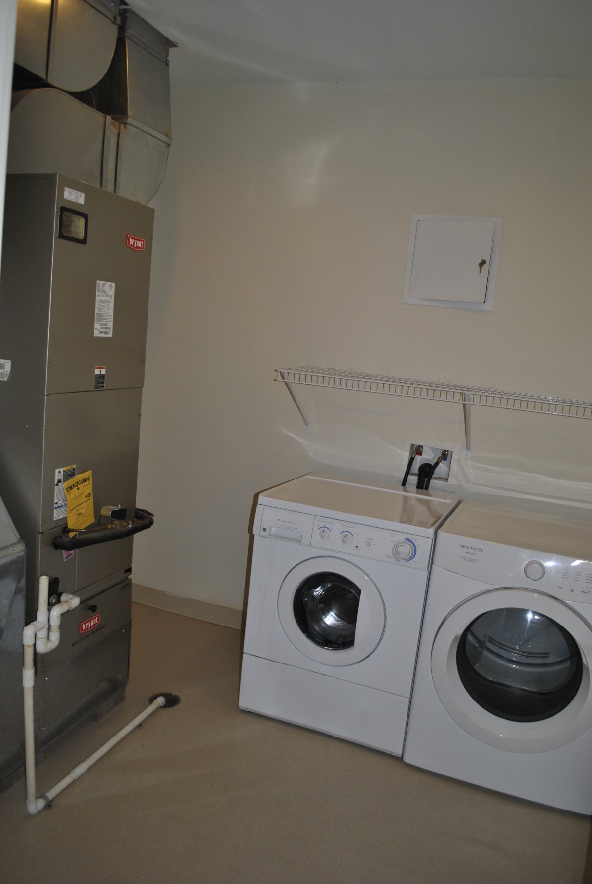 A utility room featuring a washing machine, dryer, and water heater.