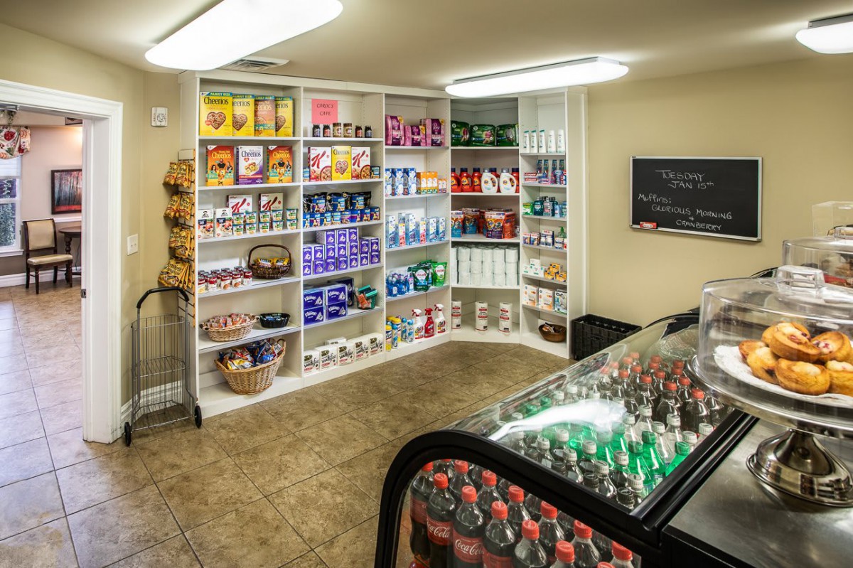 A small store with shelves stocked with various grocery items, snacks, and beverages.