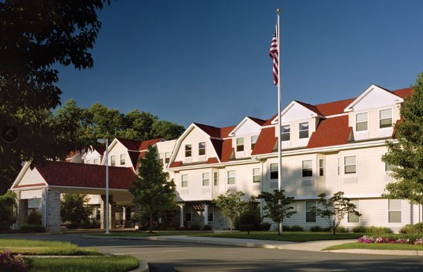 A building with a red roof and an American flag on a sunny day.